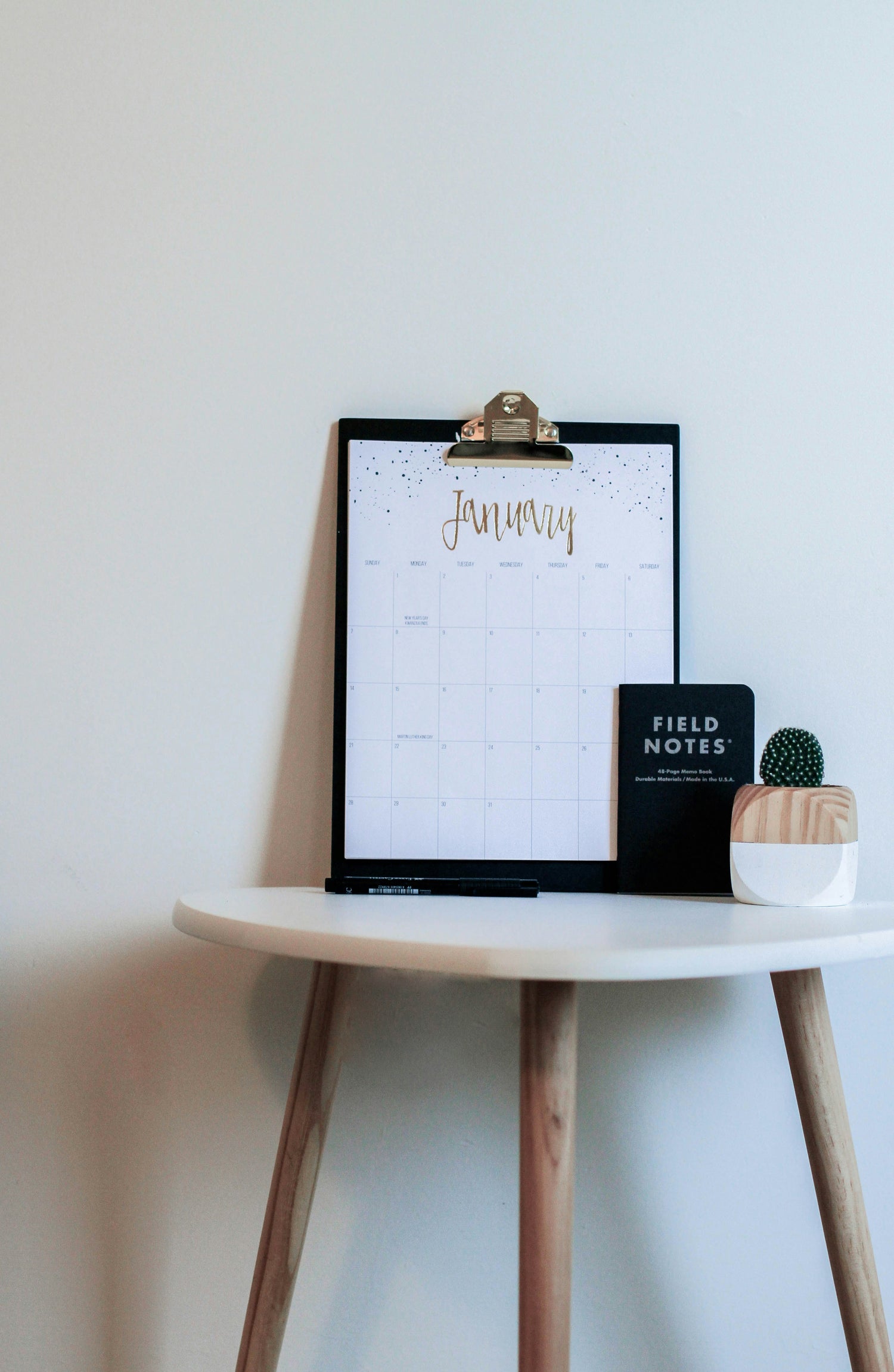 Calendar on a small wooden table with a white background
